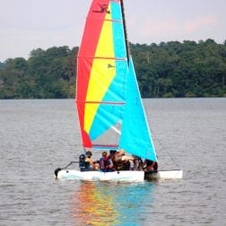 A group of campers sailing a small boat on Lake Livingston.