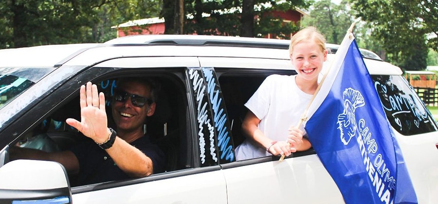 father and daughter arriving at camp in a car