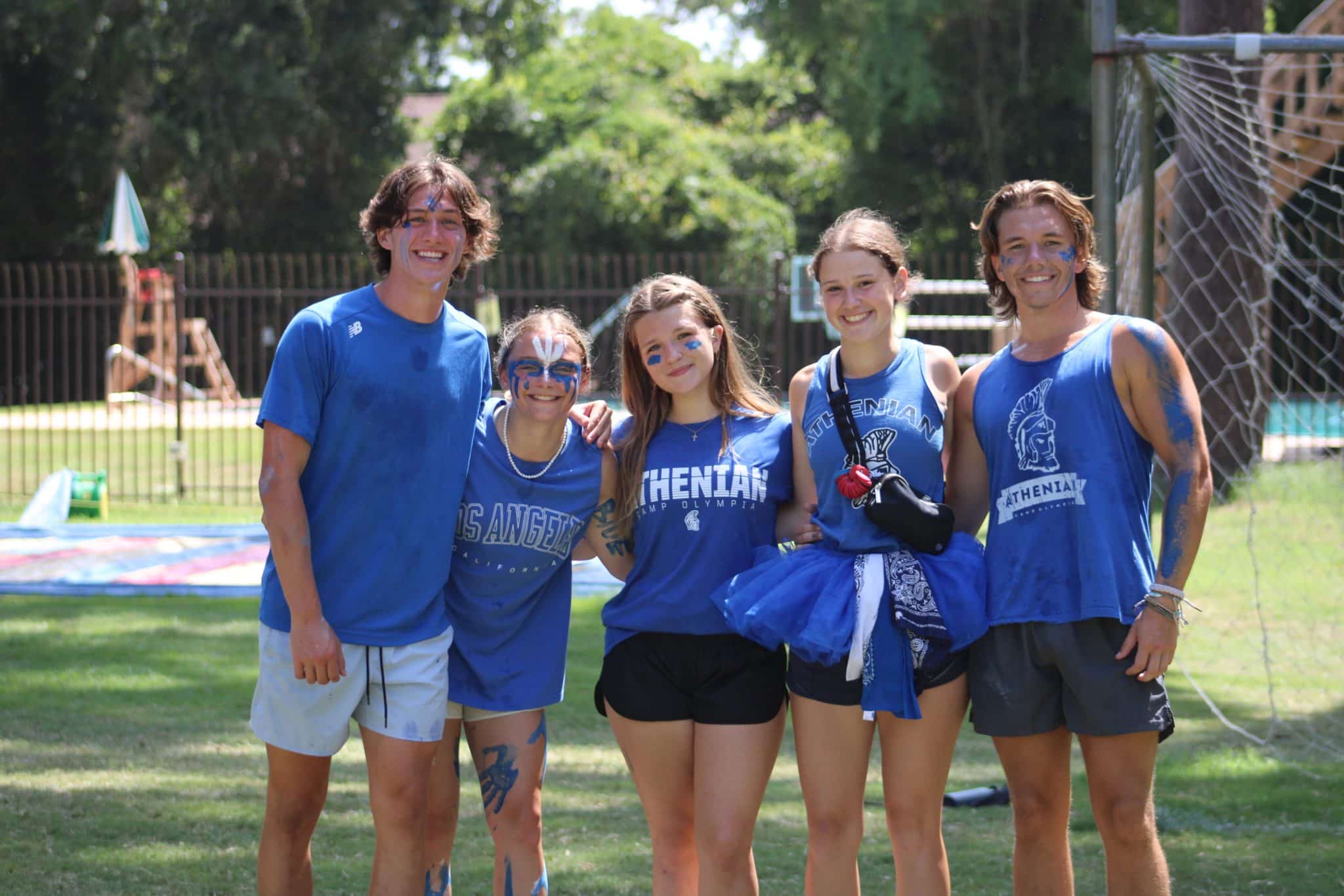 camp olympia counselors in blue athenian shirts and face paint