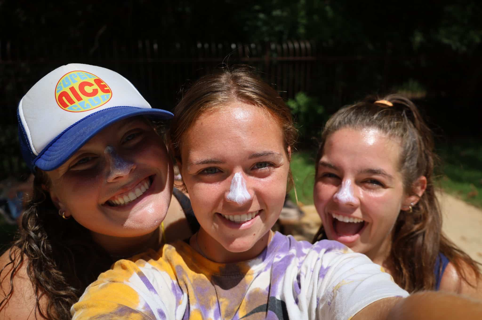 three female counselors taking selfie with sunscreen on noses