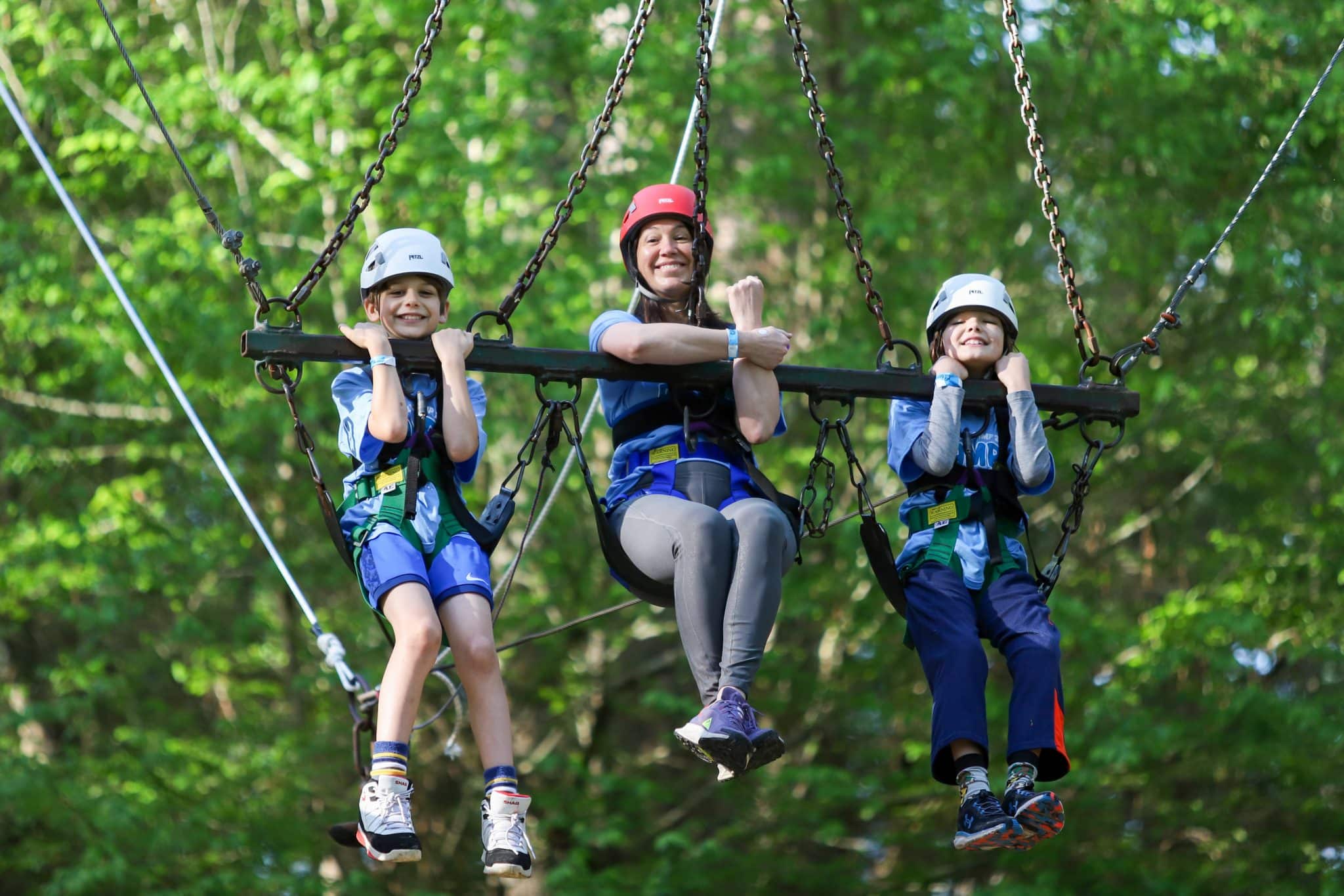Mom and sons smiling on Camp Olympia Giant Swing.