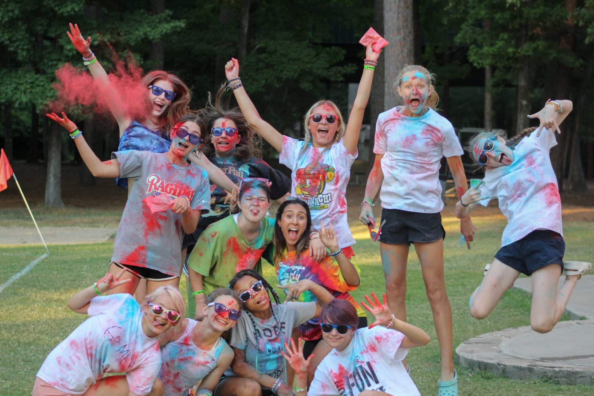 Group of Camp Olympia friends and counselor with red chalk powder.