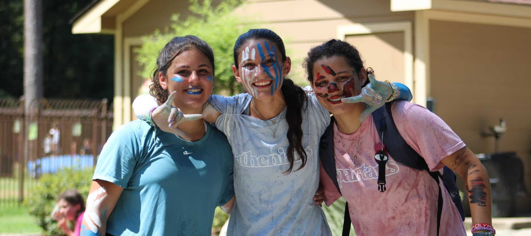 three campers with face paint ready for summer camp competition